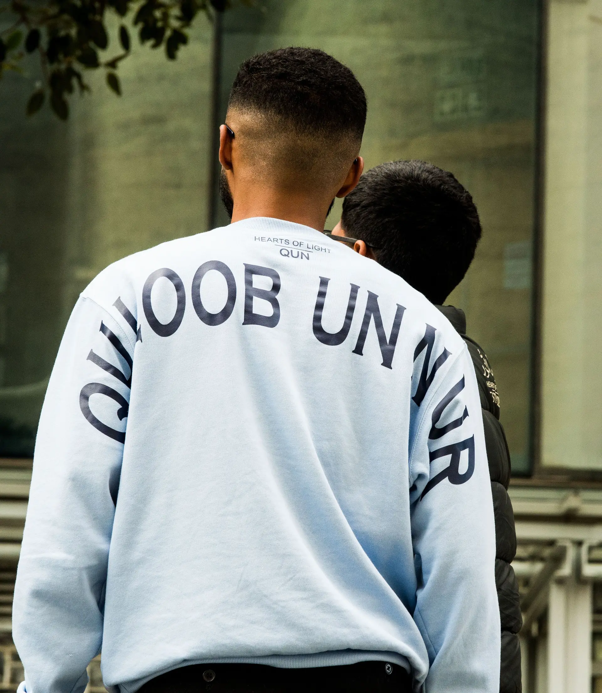 Powder blue crewneck from behind, name across the shoulders