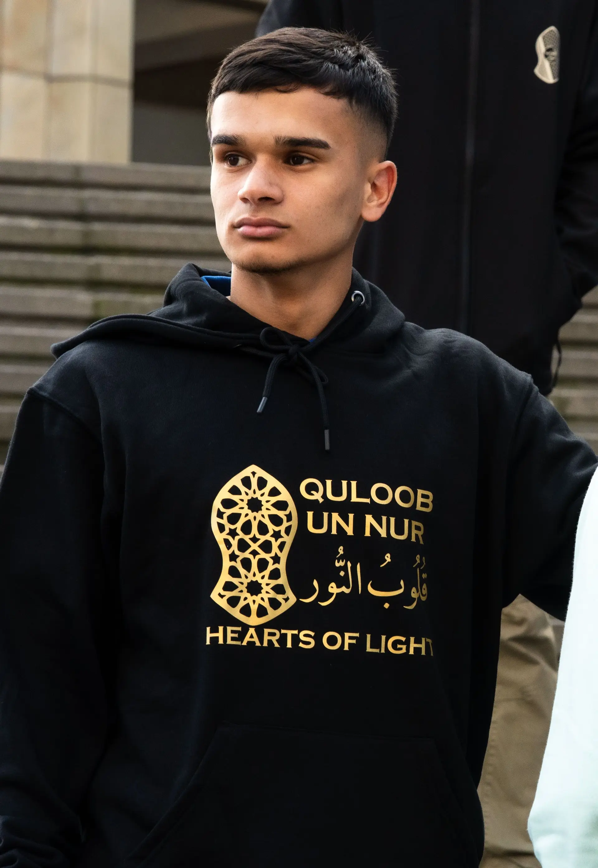 Black hoodie with the lockup printed in gold