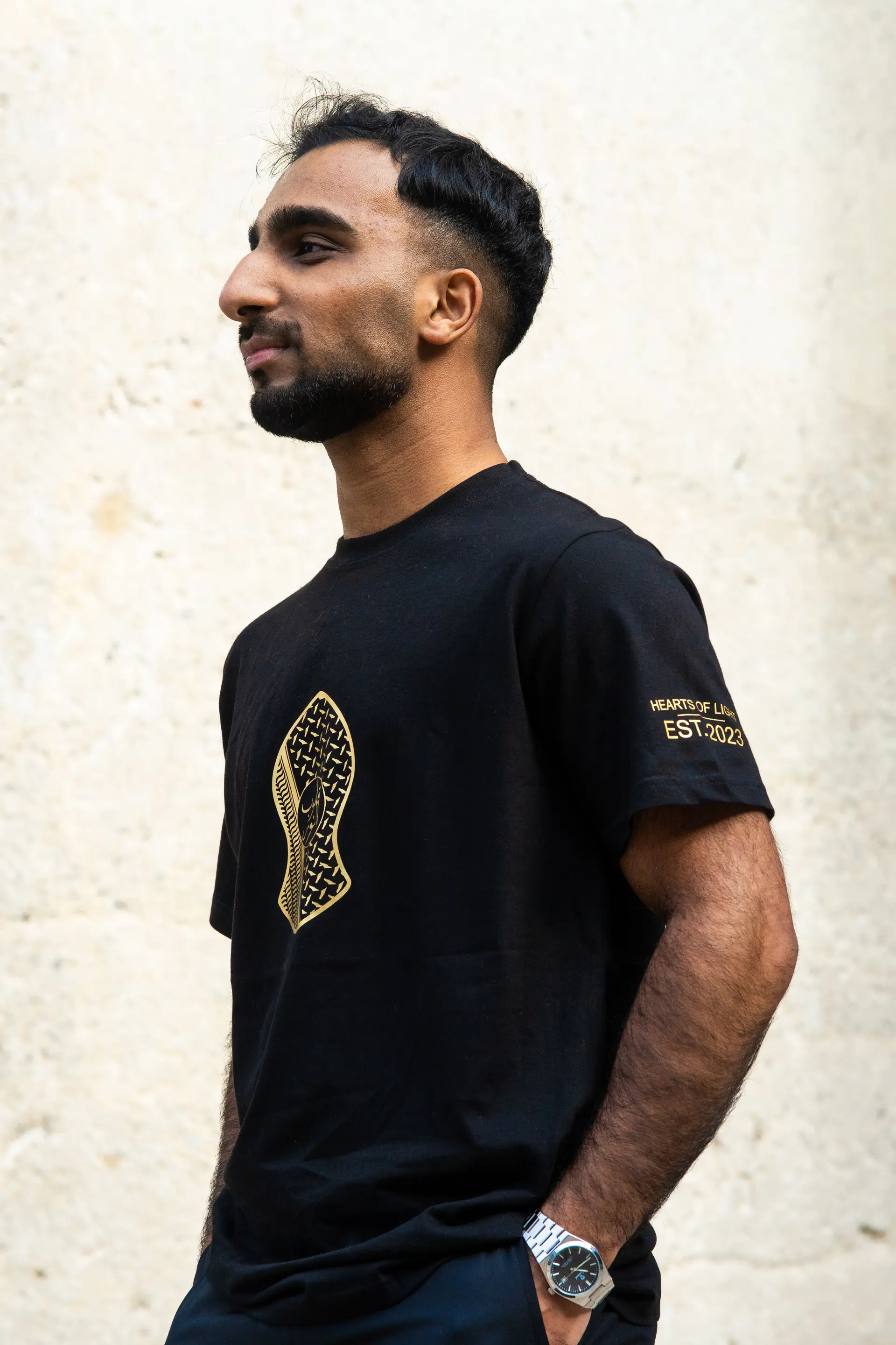 Black t-shirt with the logo printed in gold on the chest